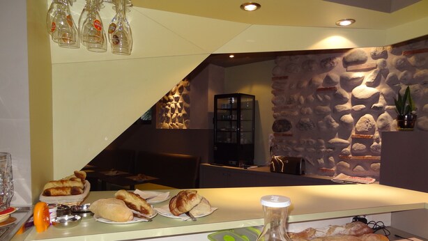 A breakfast buffet with various pastries, a bottle of orange juice, and condiments.