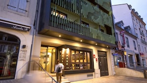 A hotel with a modern facade, a staircase leading to the entrance, and a sign indicating it is a hotel.