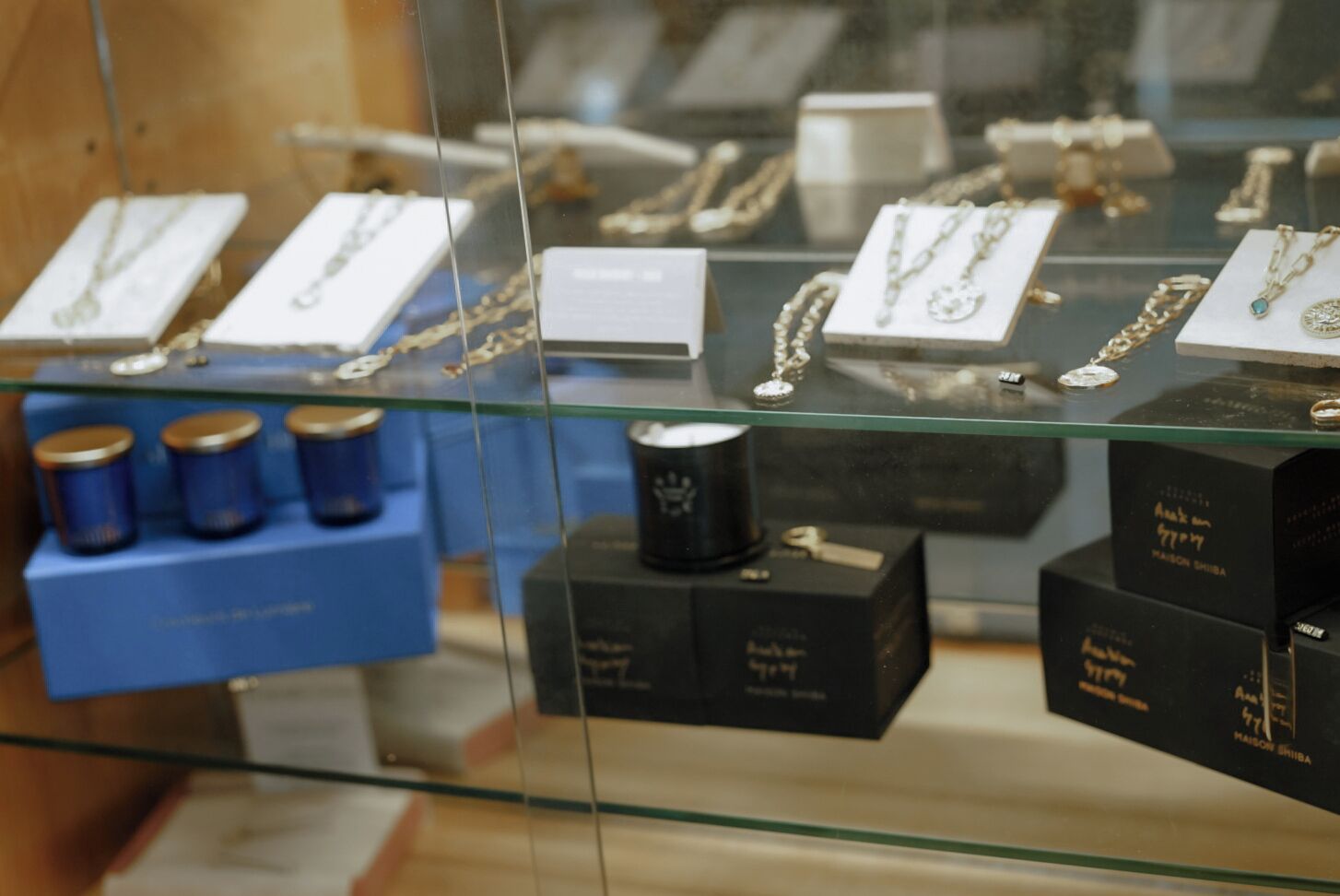 Une vitrine à bijoux contenant divers colliers et une boîte bleue étiquetée « CIGARETTES ».