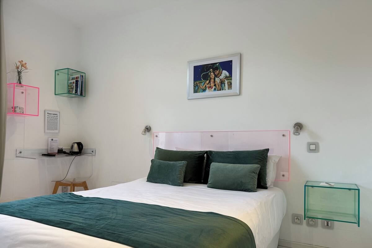A neatly arranged hotel room with a bed, a desk, and a small table.
