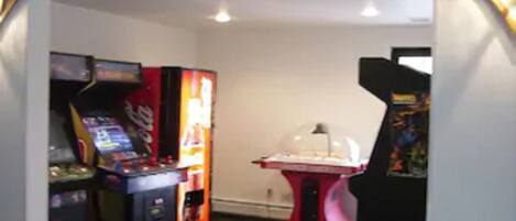 A GAME ROOM with arcade machines and a claw machine.