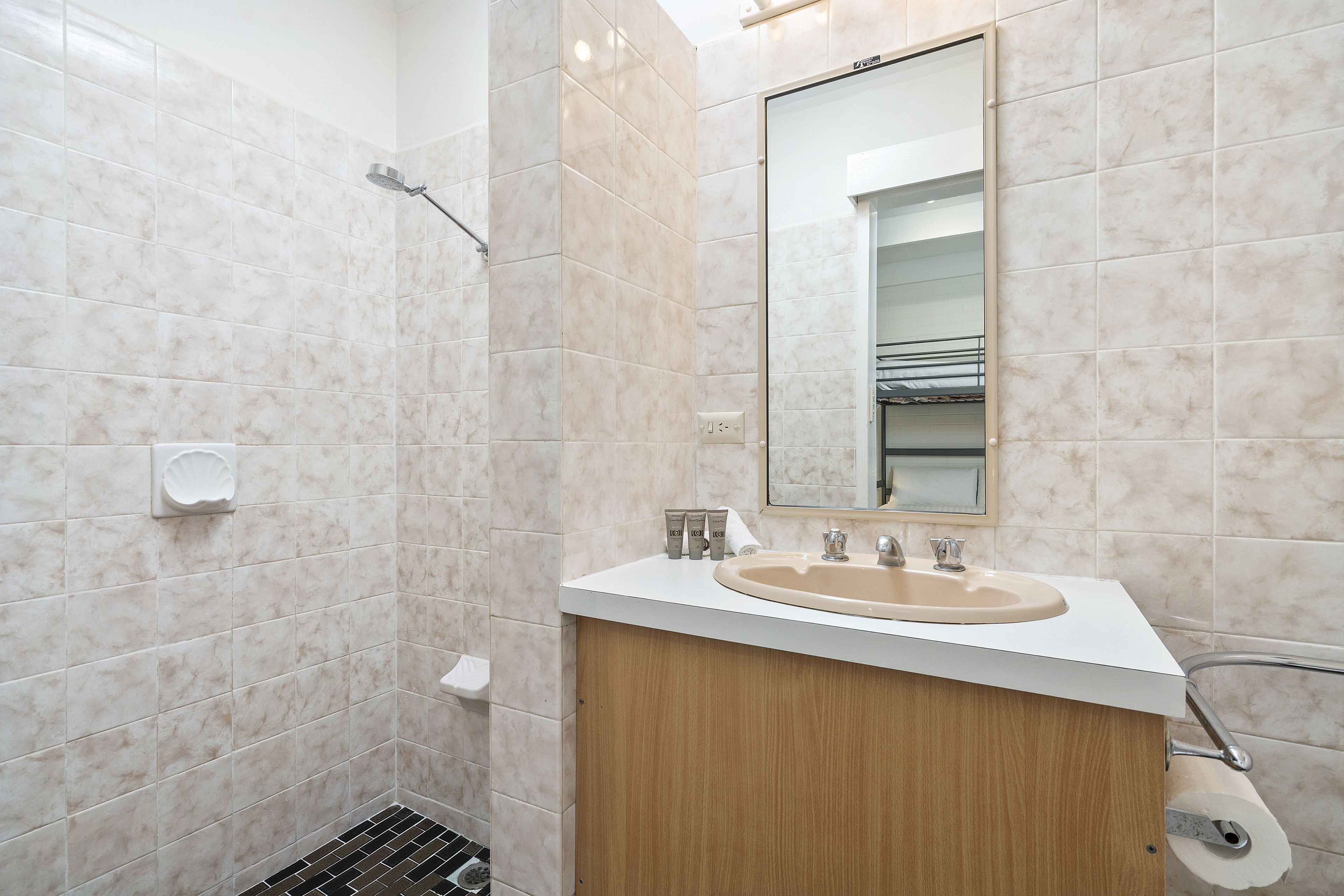 A modern bathroom with a shower, sink, and mirror.