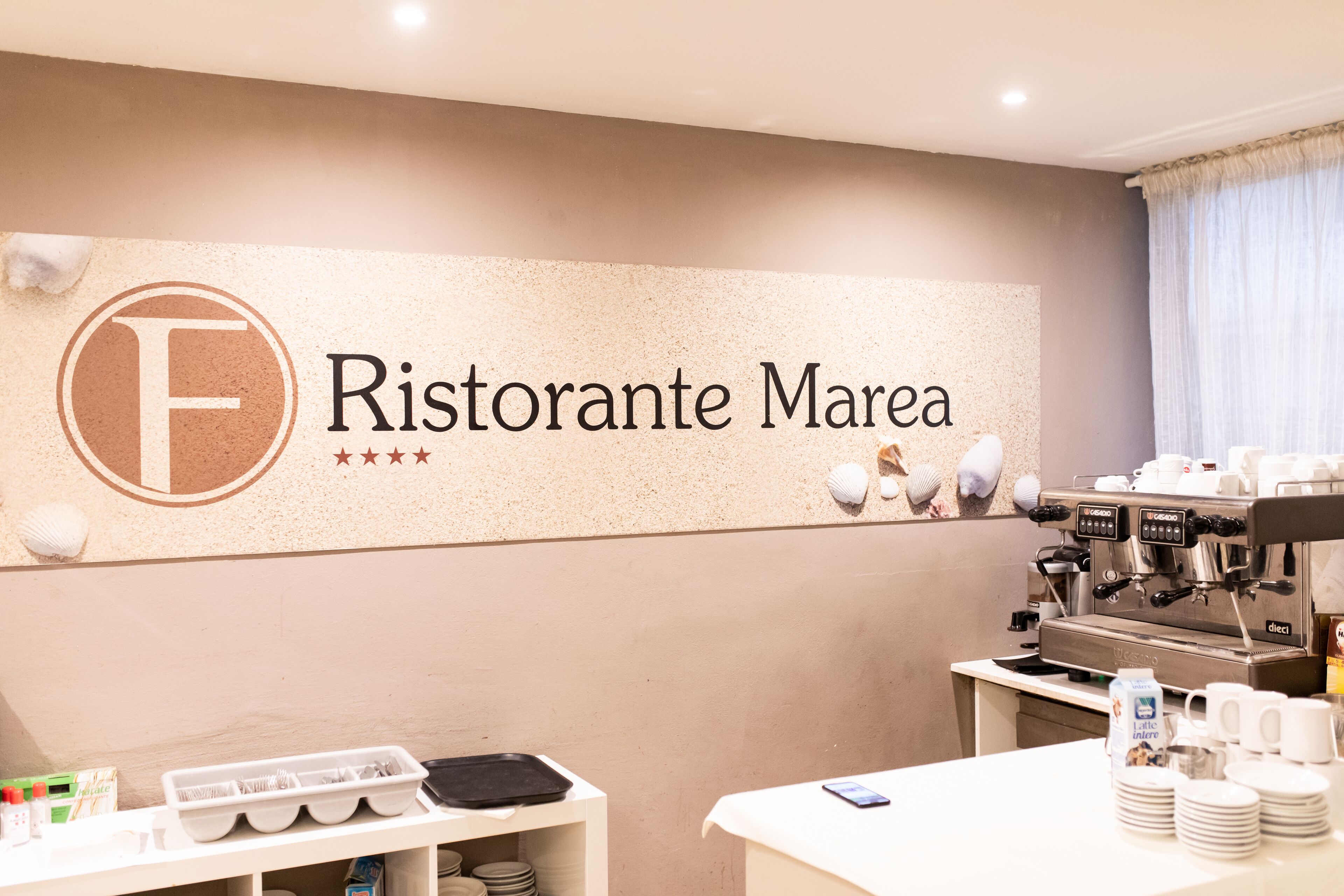 A wall with a sign reading "Ristorante Marea" and a coffee machine.