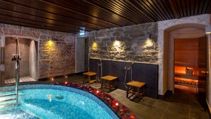 A spa area with a pool, wooden benches, and a stone wall. - The von Stackelberg Hotel Tallinn (Tallinn)