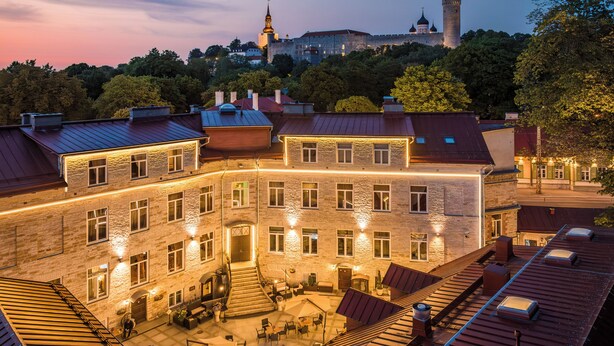 A multi-story building with a courtyard, stone facade, and a tower in the background. - The von Stackelberg Hotel Tallinn (Tallinn)