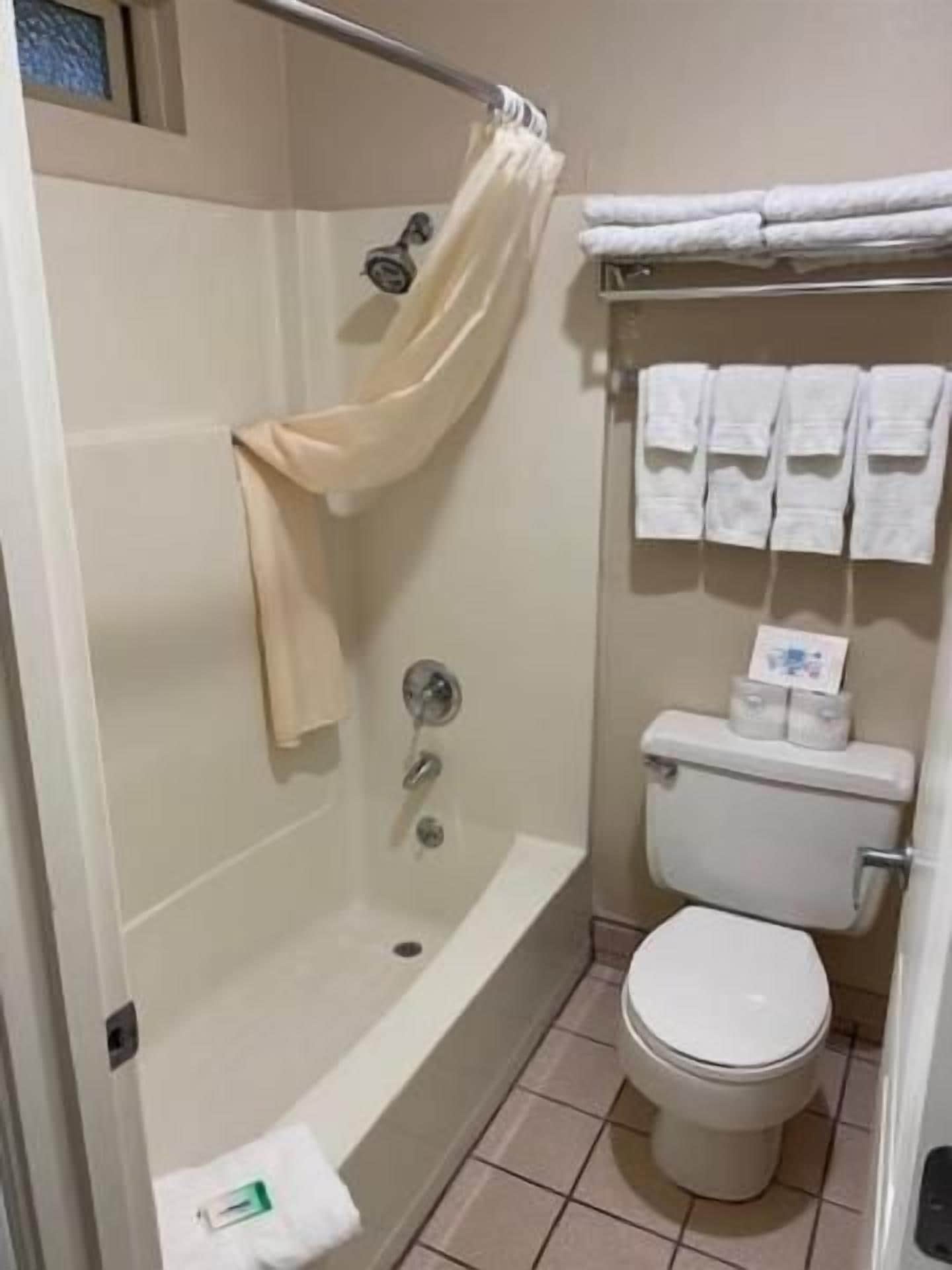 Et badeværelse med badekar, toilet og håndklædetørrestativ.