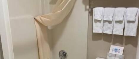 Un baño con bañera, inodoro y perchero para toallas.