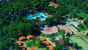 An aerial view of a resort with multiple buildings, a swimming pool, and a sports court. - Settebello Village (Fondi)