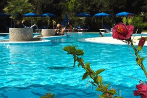 Una piscina al aire libre de temporada, sombrillas