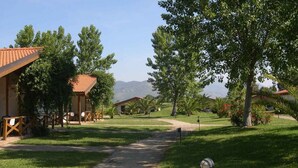 A resort with multiple buildings, a paved walkway, and lush greenery. - Settebello Village (Fondi)