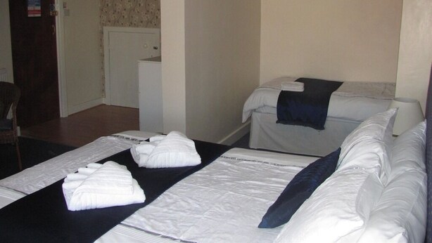 Una habitación de hotel con una cama, una silla y un escritorio.