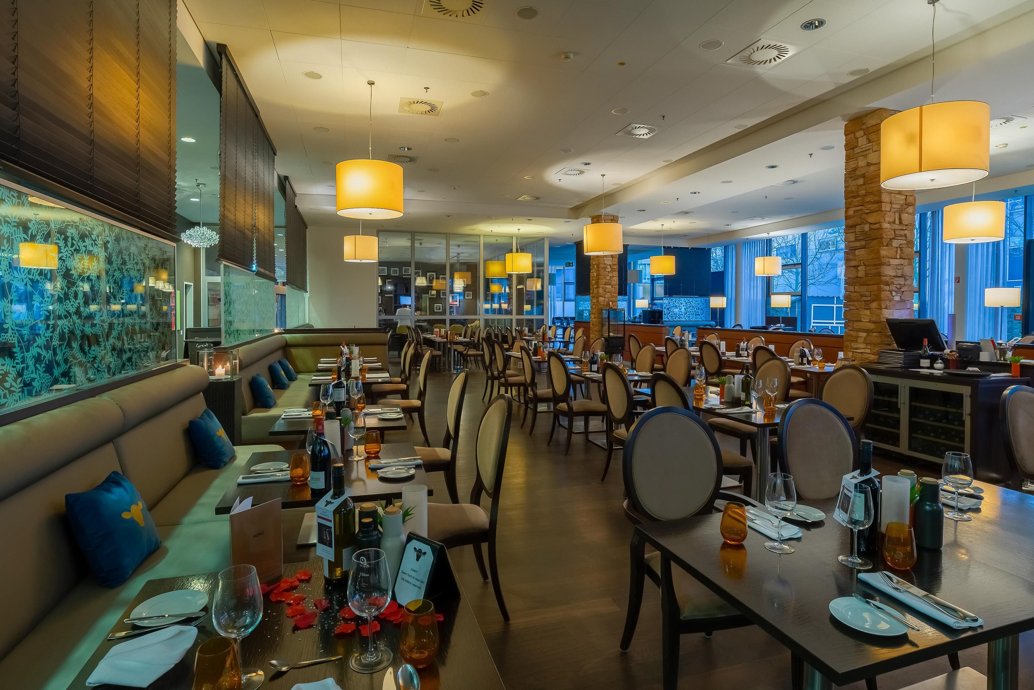 Un restaurante con cabinas, mesas y una zona de bar.