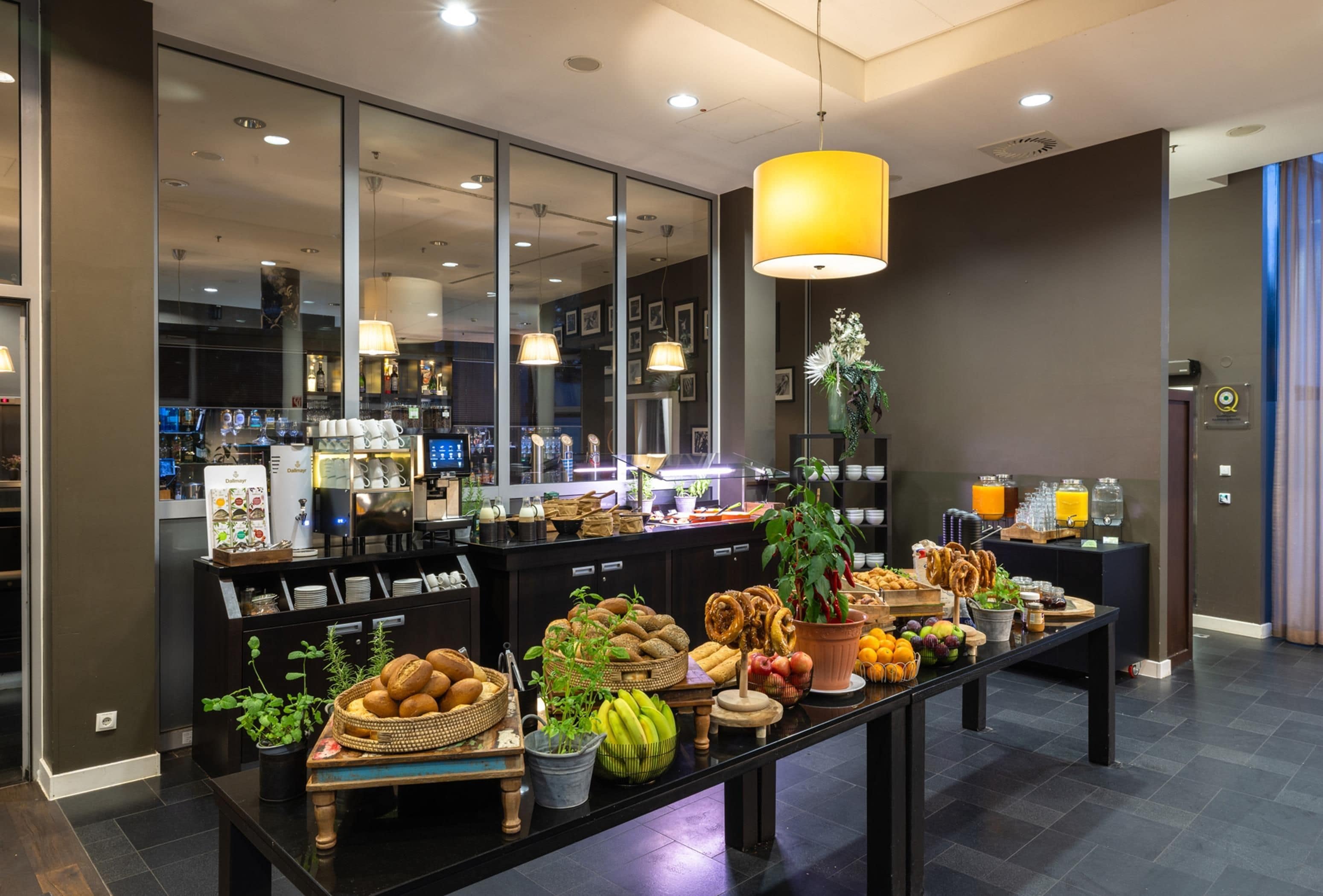 Un bufé de desayuno con una variedad de panes, frutas y bebidas.
