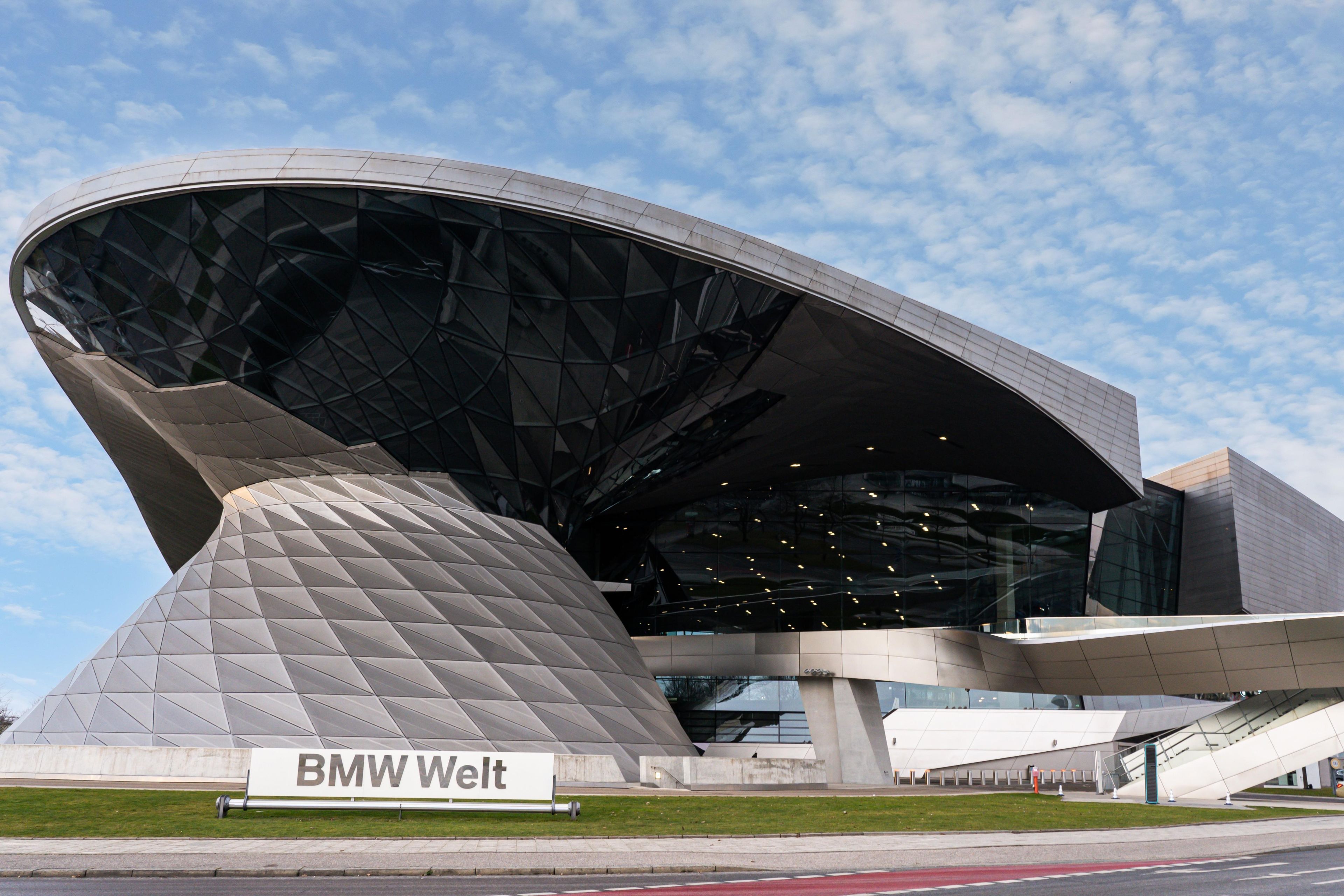 Ein modernes, architektonisch gestaltetes Gebäude mit einem markanten, gewölbten Design, beschriftet mit 'BMW Welt'.
