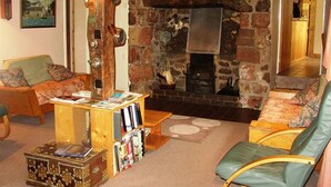 A cozy living room with a stone fireplace, wooden beams, and comfortable seating. - Brownhill House (Shrewsbury)