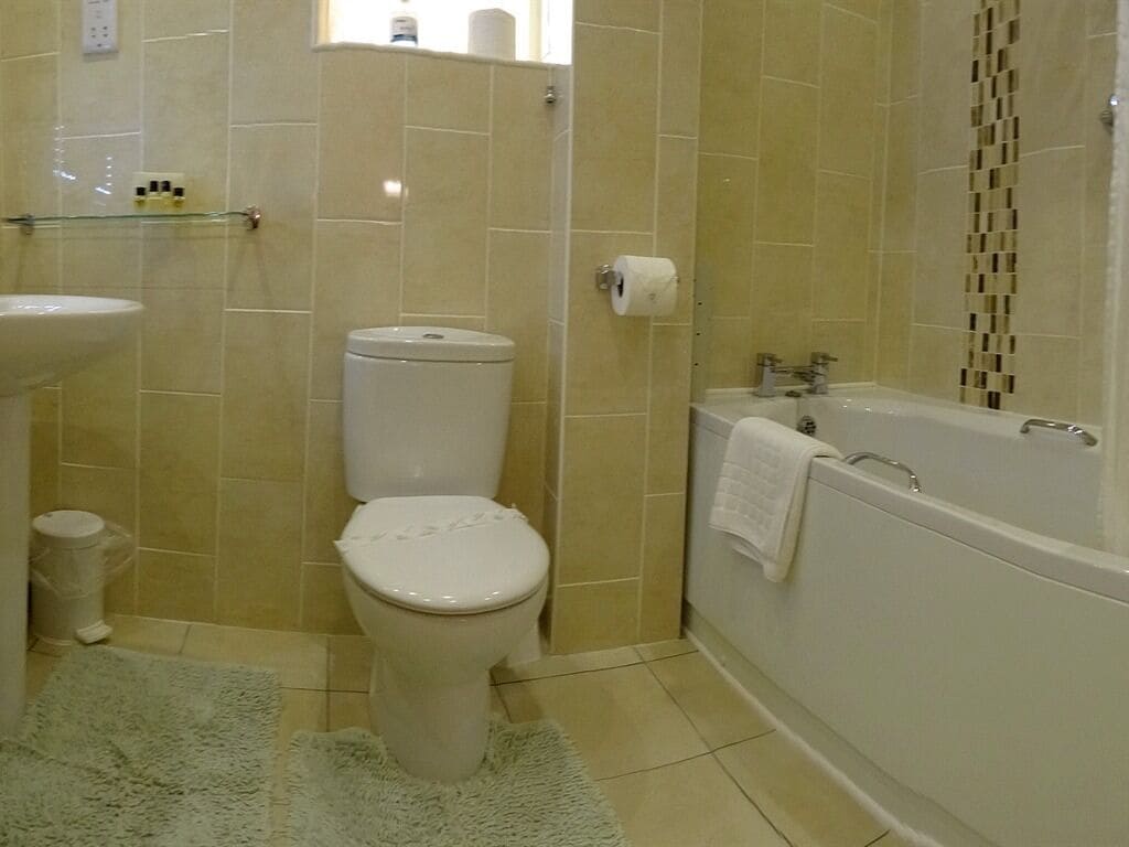 A bathroom with a toilet, sink, and bathtub.