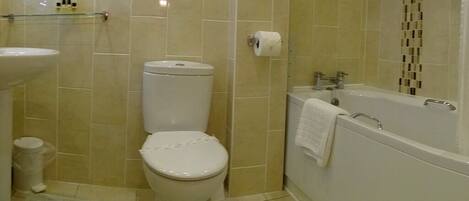 A bathroom with a toilet, sink, and bathtub.