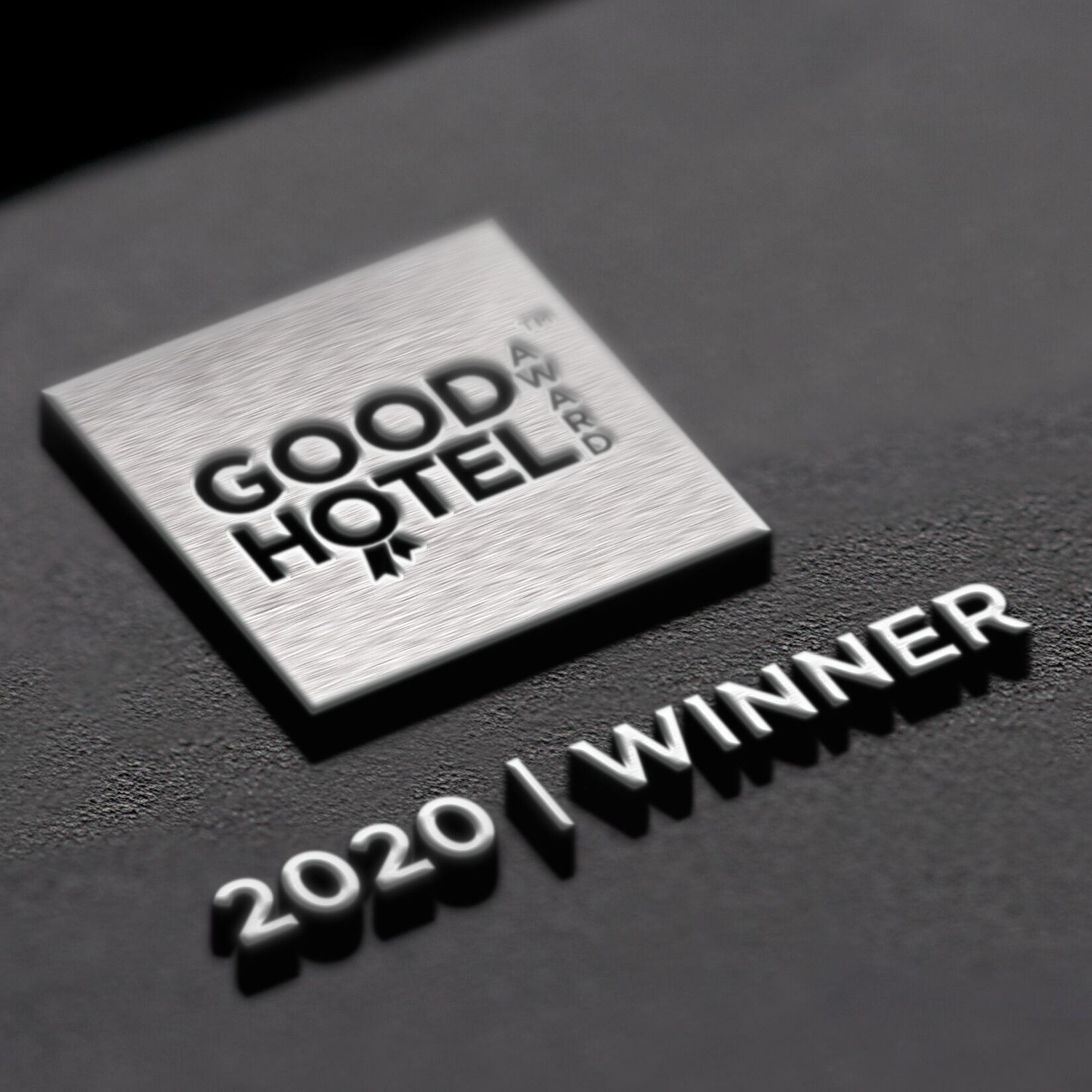 A metallic plaque with "GOOD HOTEL" and "2020 WINNER" engraved on it.