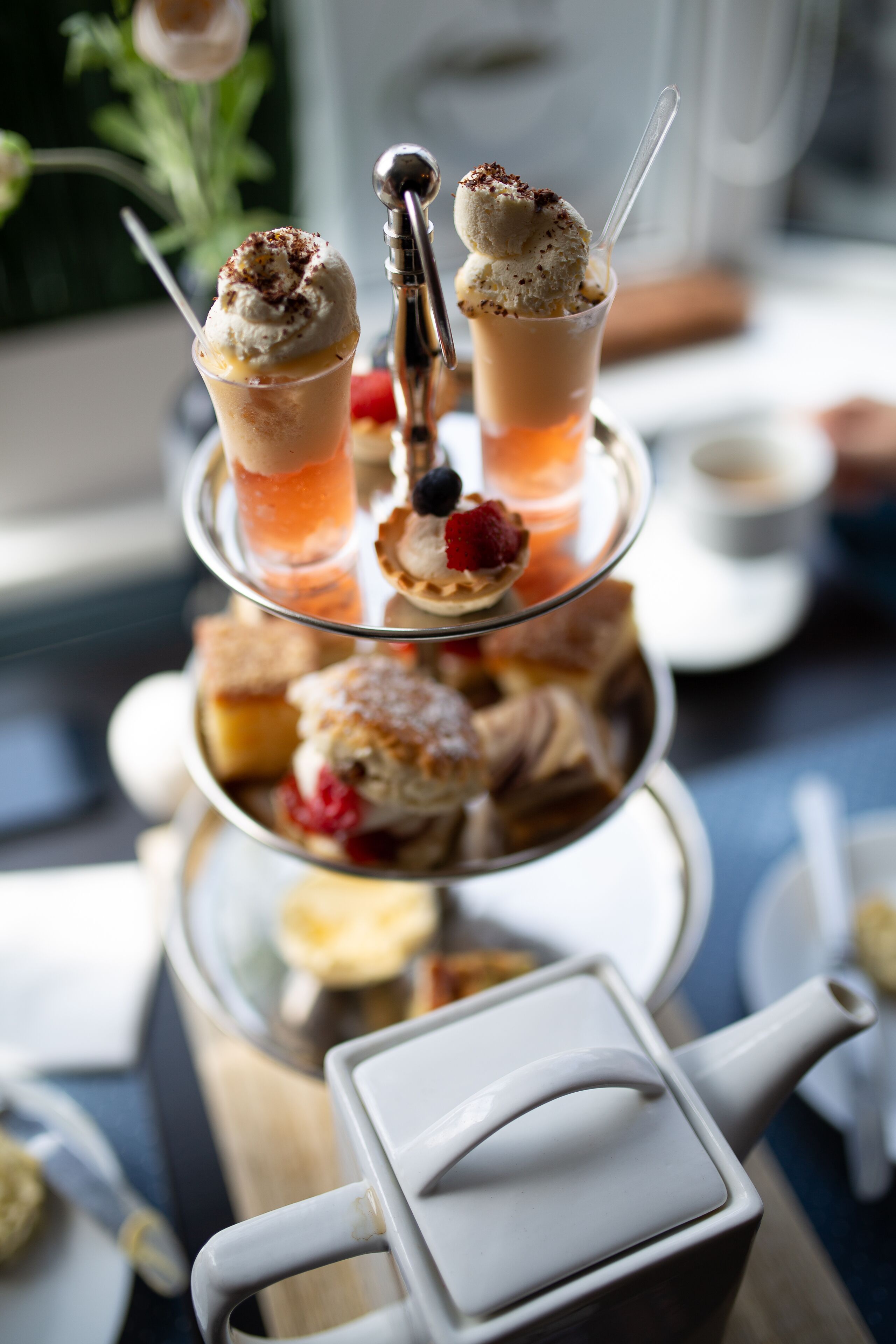 A tiered dessert stand with various pastries and ice cream.