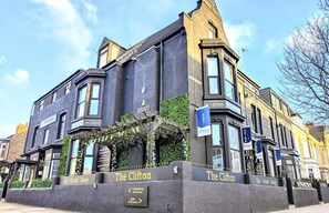 A building with signs reading "The Clifton" and "Eat Drink Sleep". There are signs for a coffee shop entrance and the main entrance. - Clifton Guest House (South Shields)