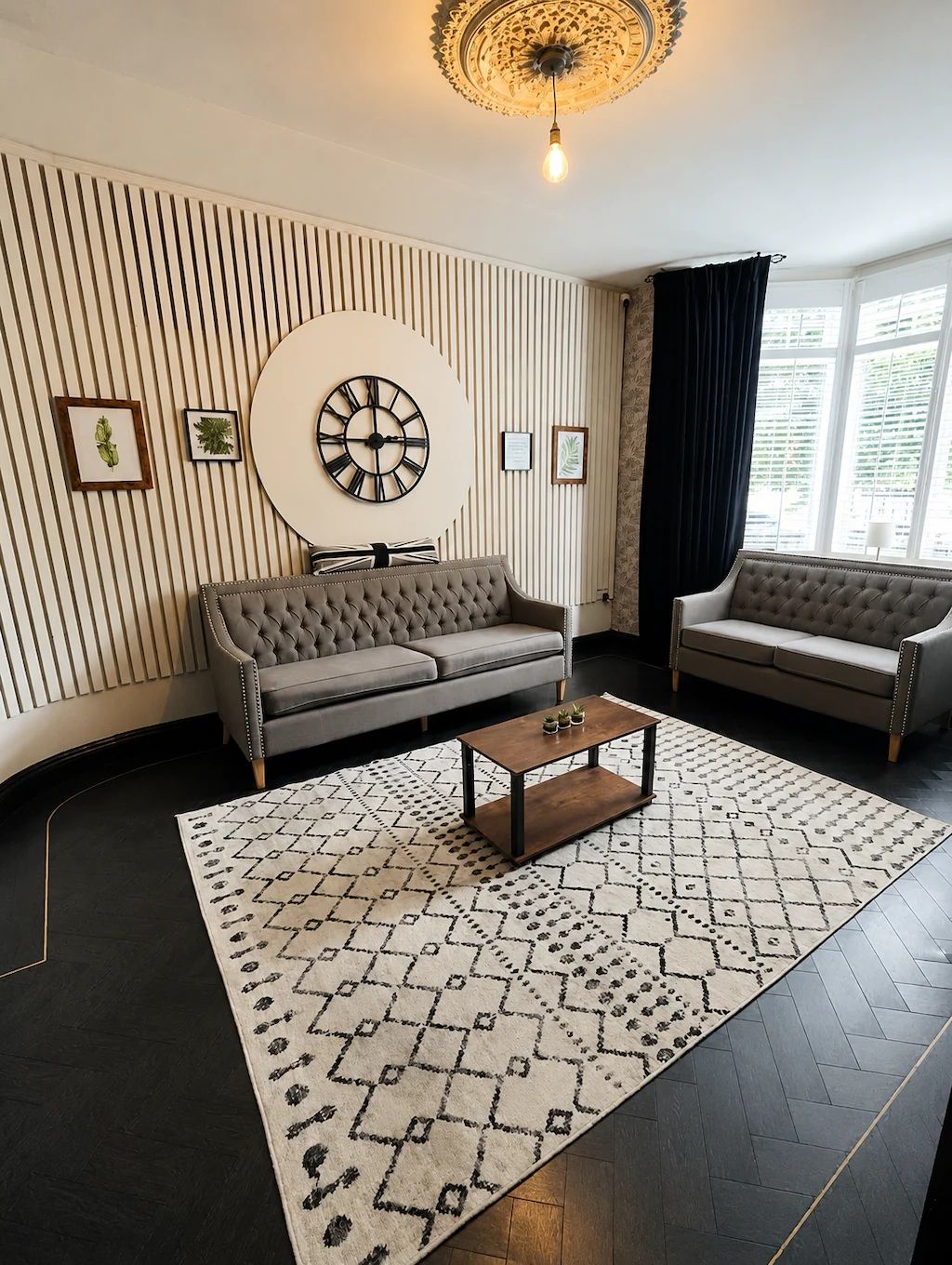 A modern living room with a sofa, a coffee table, and a decorative wall clock.