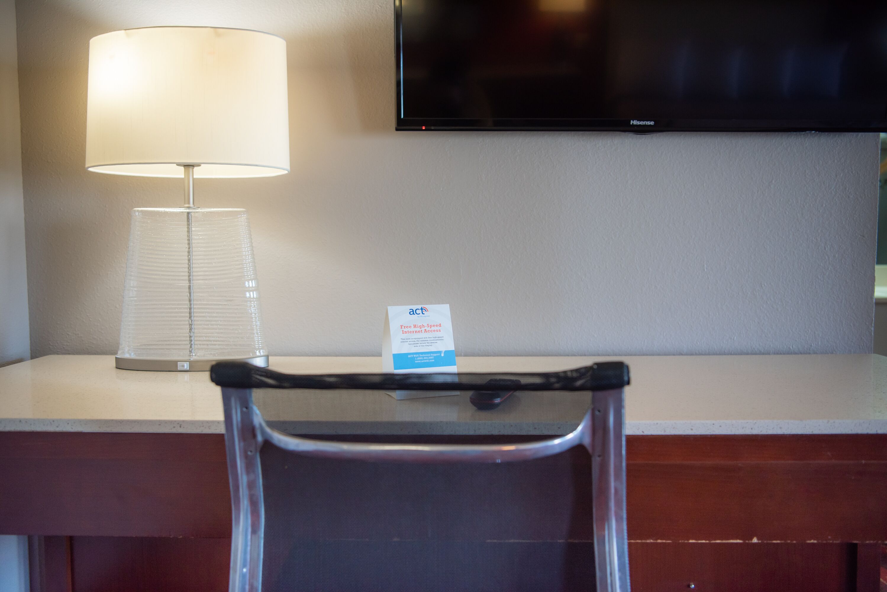 Une chambre d’hôtel équipée d’un bureau, d’une lampe, d’un téléviseur et d’une pancarte indiquant le type de chambre.