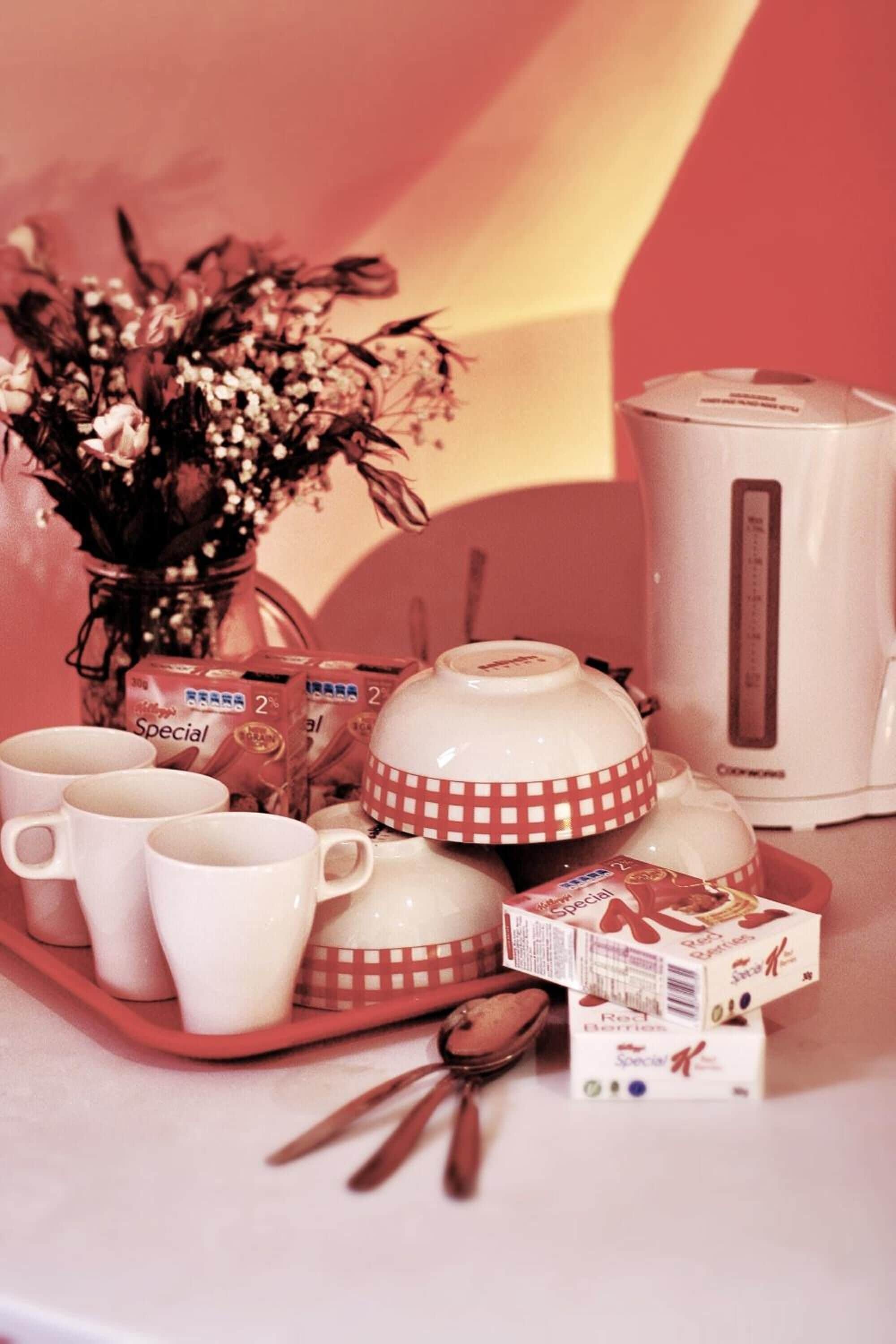 A kitchen counter with a tea set, a coffee maker, and some boxes of tea.