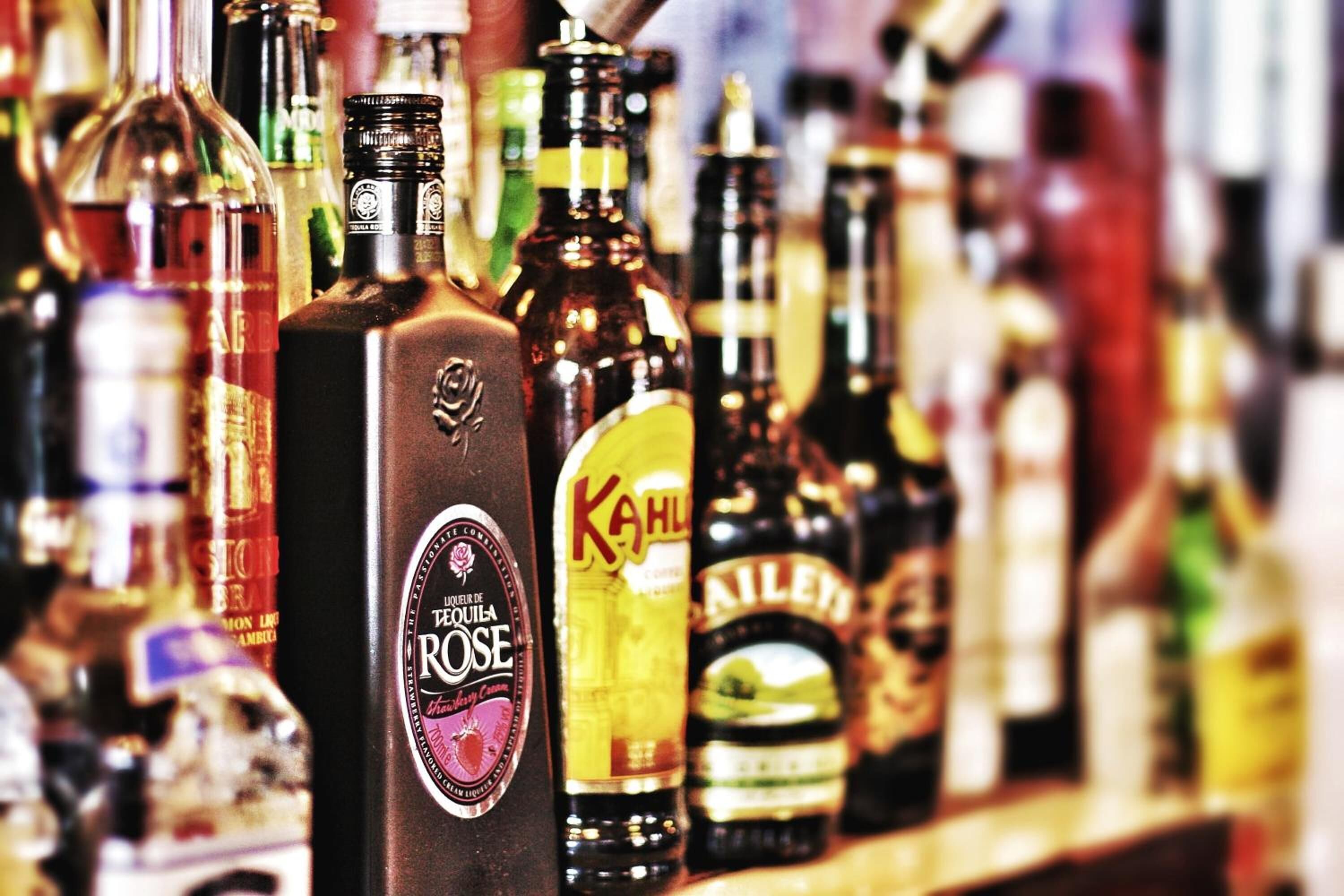 A variety of liquor bottles on a shelf.