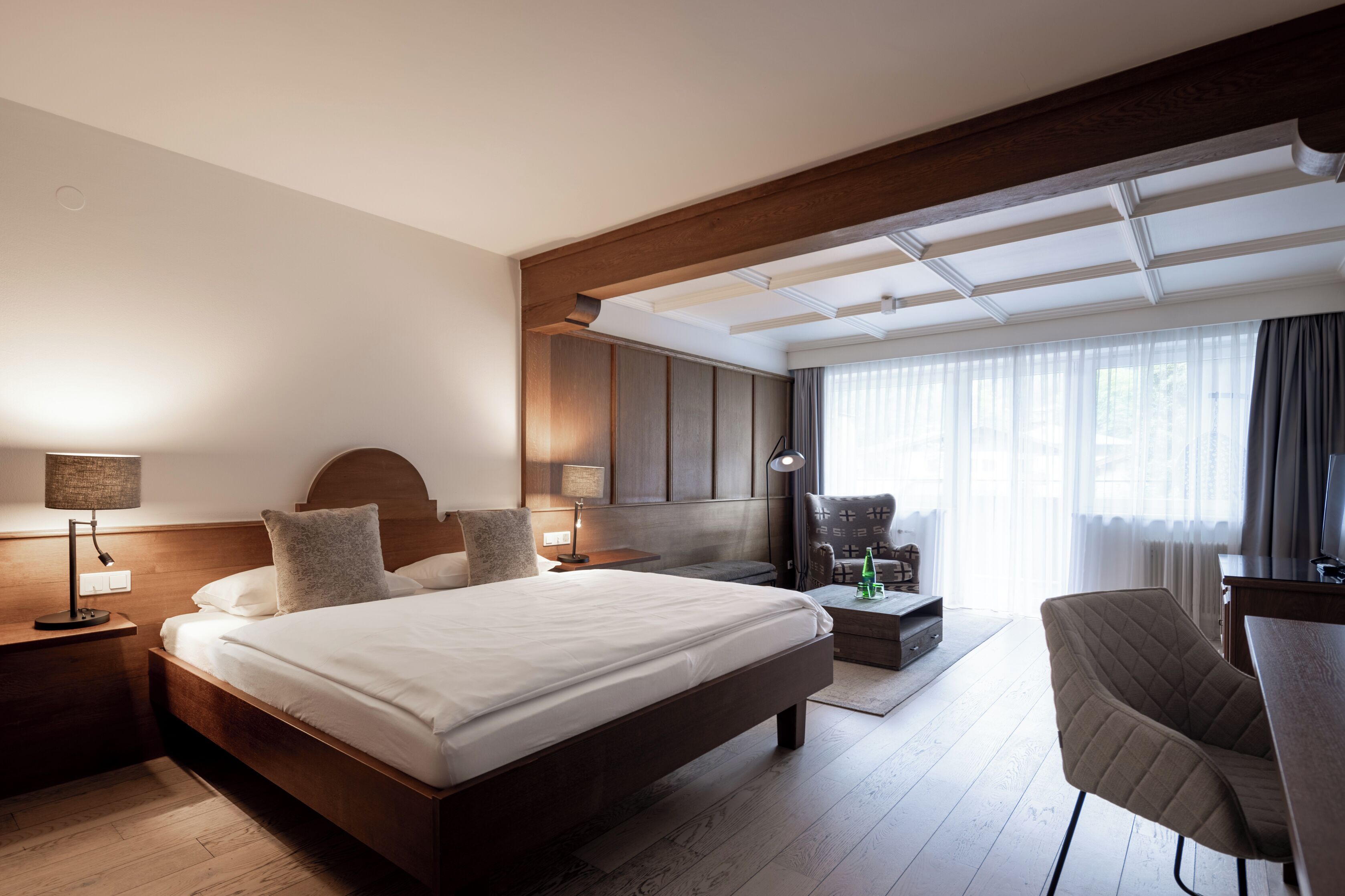 Une chambre d’hôtel moderne, dotée d’un grand lit, d’un bureau et d’une chaise.