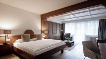 Une chambre d’hôtel moderne, dotée d’un grand lit, d’un bureau et d’une chaise.