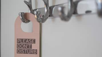A tag with the text "PLEASE DON'T DISTURB" attached to a metal hook.