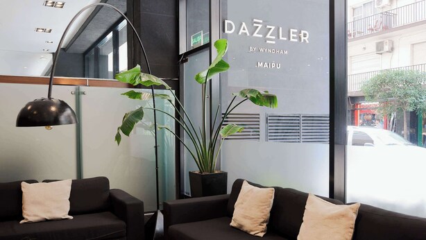 A modern interior with two black sofas, a black table, and a potted plant. - Dazzler by Wyndham Buenos Aires Maipu (Buenos Aires)
