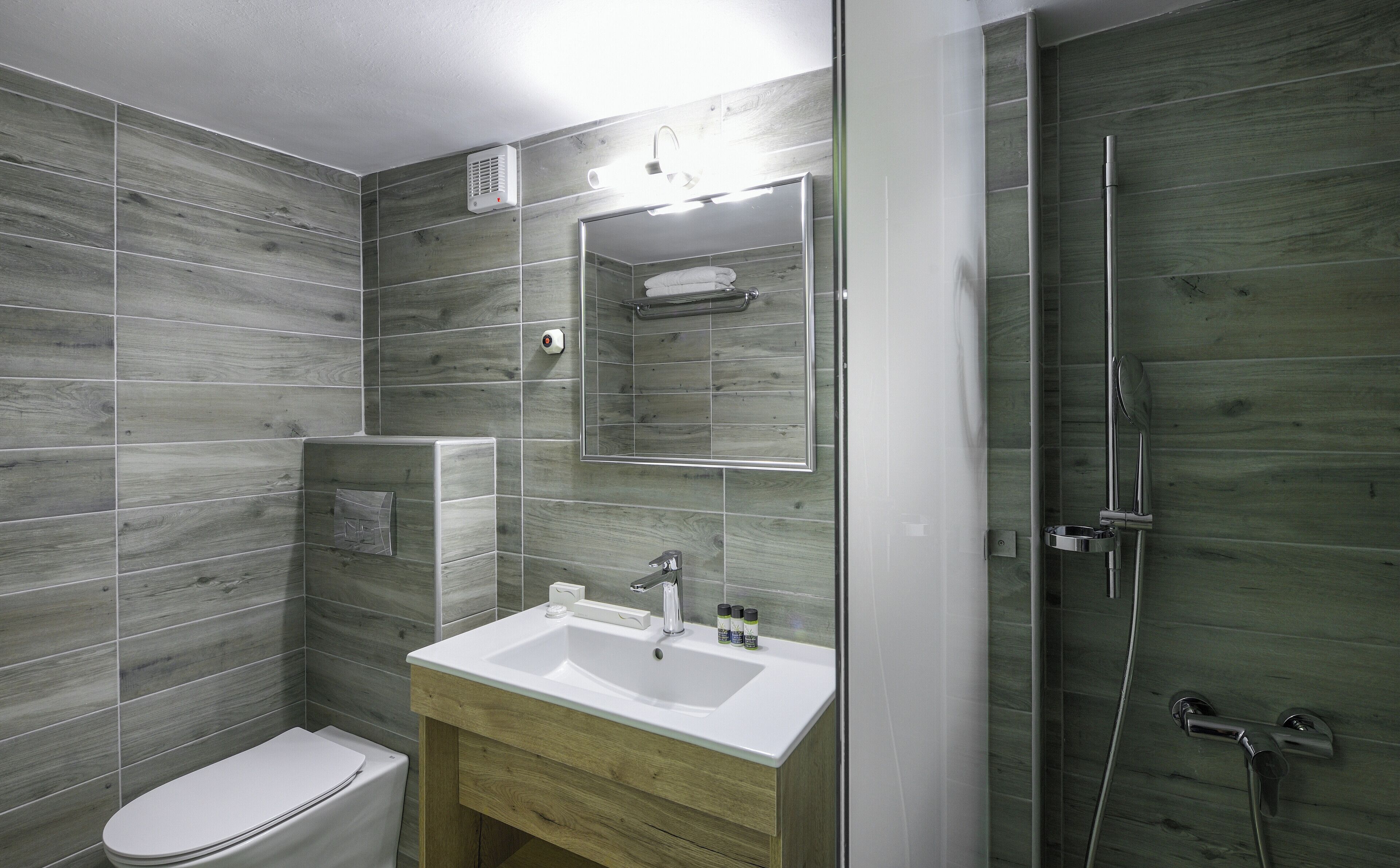 A modern bathroom with a shower, toilet, and sink.