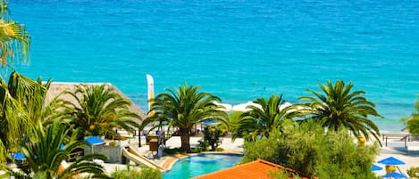 Een buitenzwembad, parasols bij het zwembad en ligstoelen