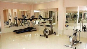A gym with various exercise equipment, including treadmills and stationary bikes, and large mirrors on the walls. - Car Hotel (Smederevo)