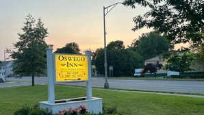 Señal del Oswego Inn con tarifas diarias y semanales, y números de contacto.