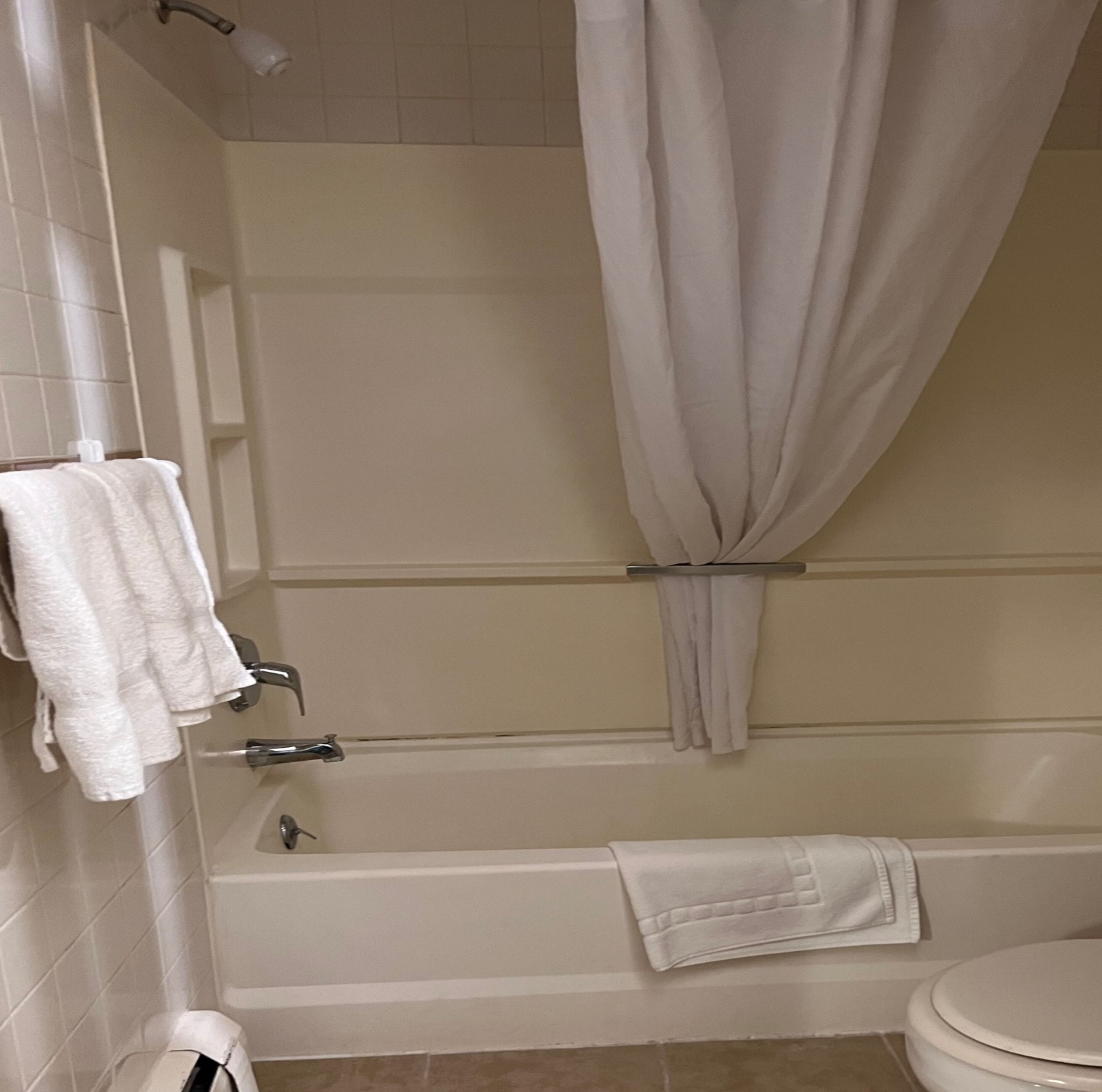 Un baño con bañera, inodoro y cortina de ducha.