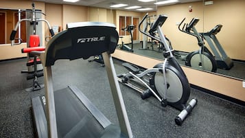 A gym with treadmills, elliptical machines, and weightlifting equipment.