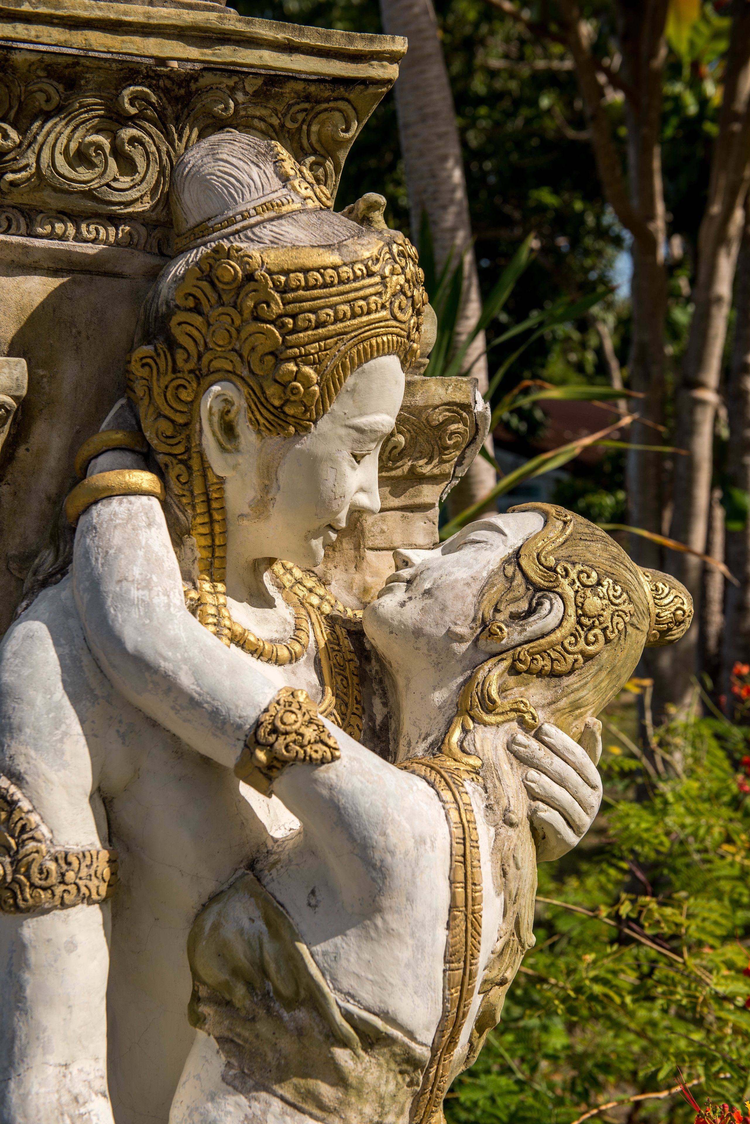 A statue of a deity with intricate carvings and a golden headdress.