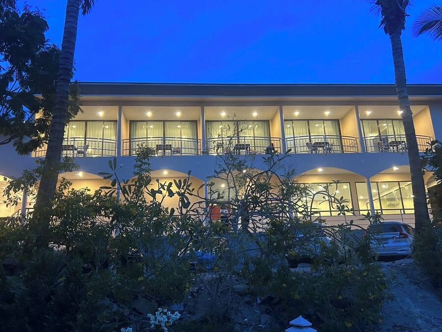 Un hotel de varios pisos con balcones y ventanas amplias.