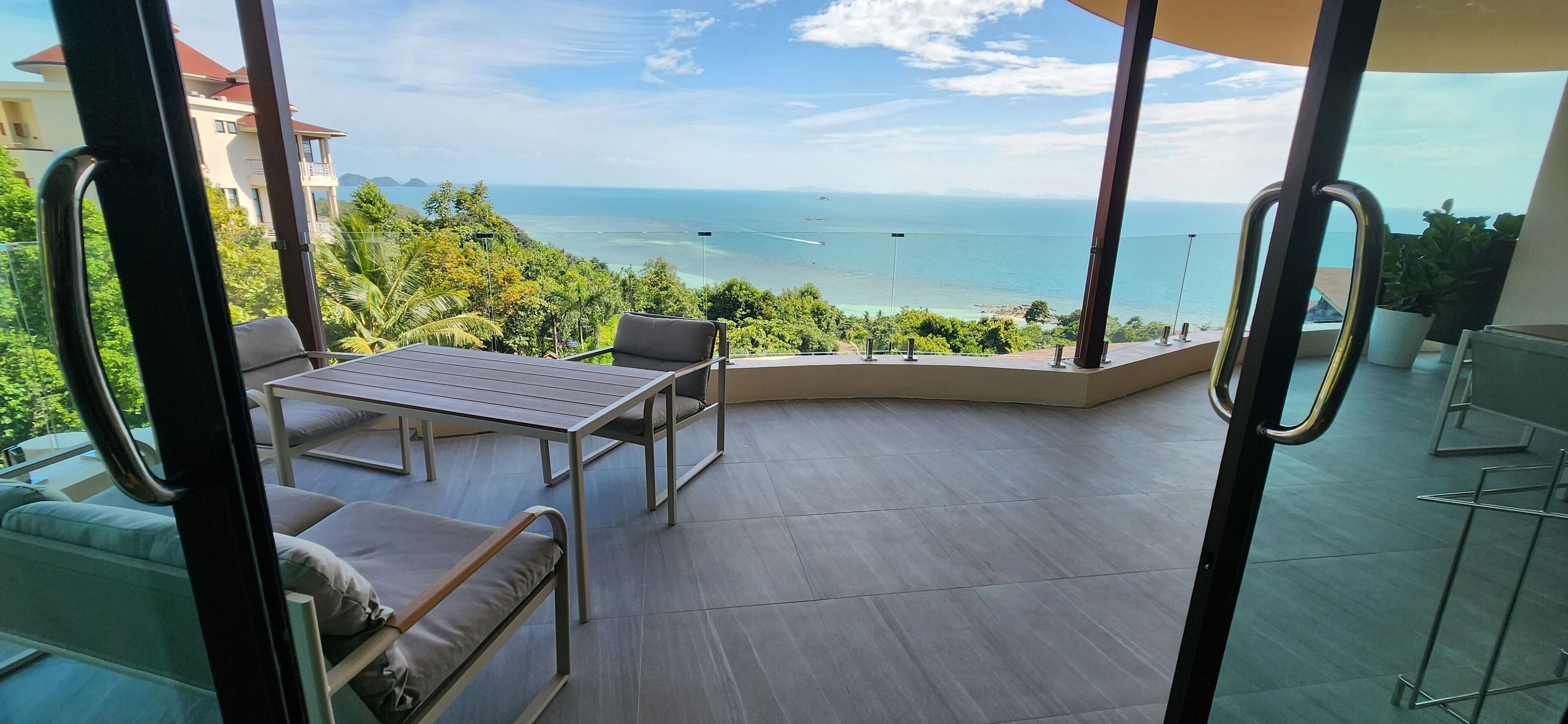 Ein Balkon mit Meerblick, einem Tisch und Stühlen.