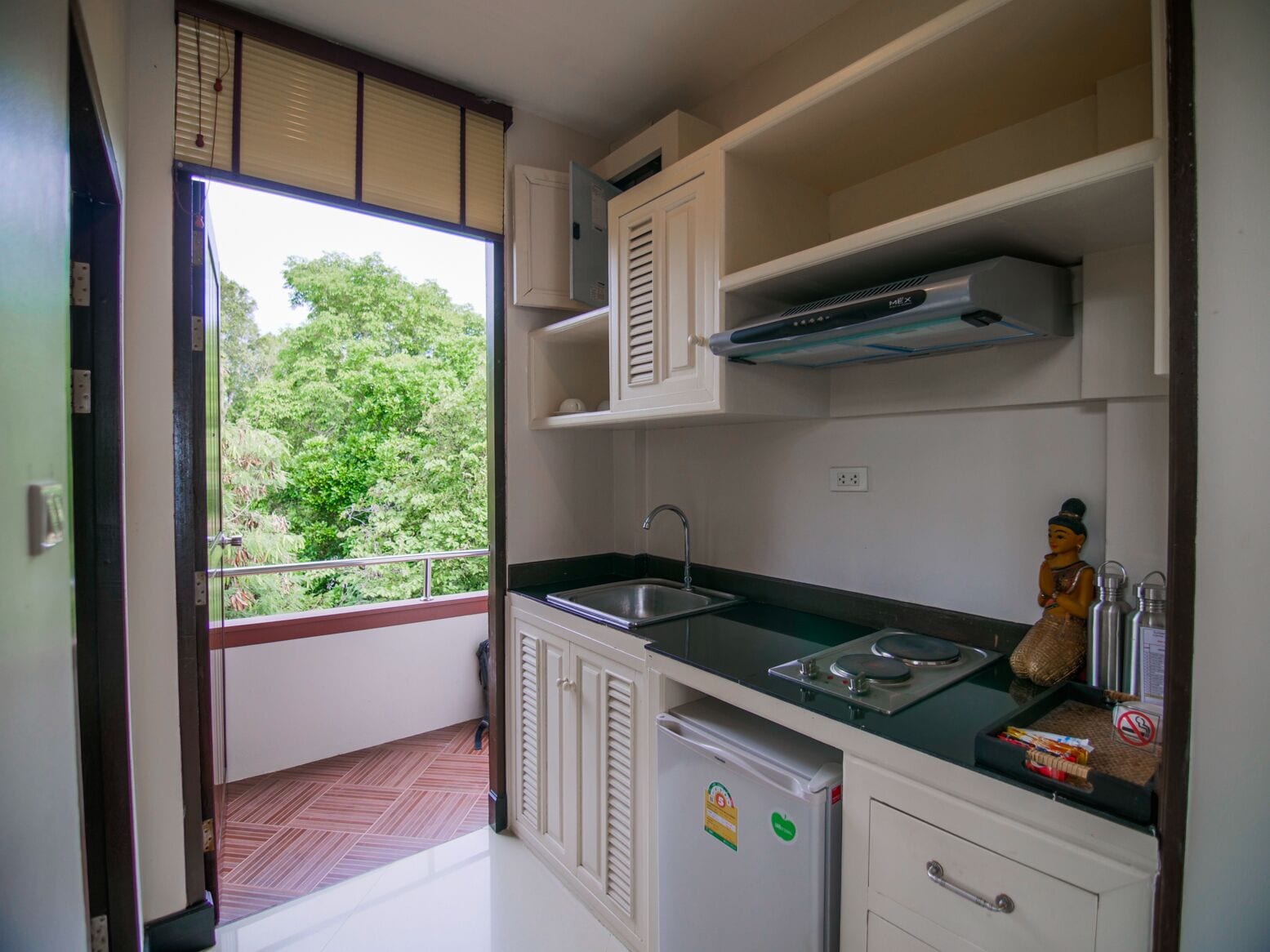 A compact kitchen with a built-in refrigerator, a sink, and a microwave.