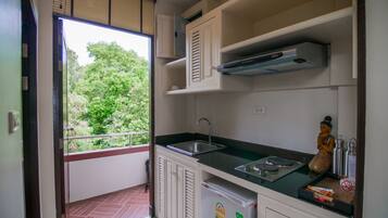 A compact kitchen with a built-in refrigerator, a sink, and a microwave.