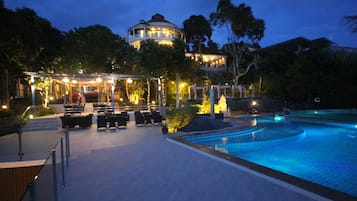 Relax by the circular pool surrounded by lush greenery and enjoy dining or unwinding in the adjacent seating area.