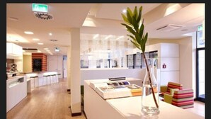 A modern hotel lobby with a reception desk, bar area, and a seating section. - harry’s home Linz-Urfahr hotel & apartments (Linz)