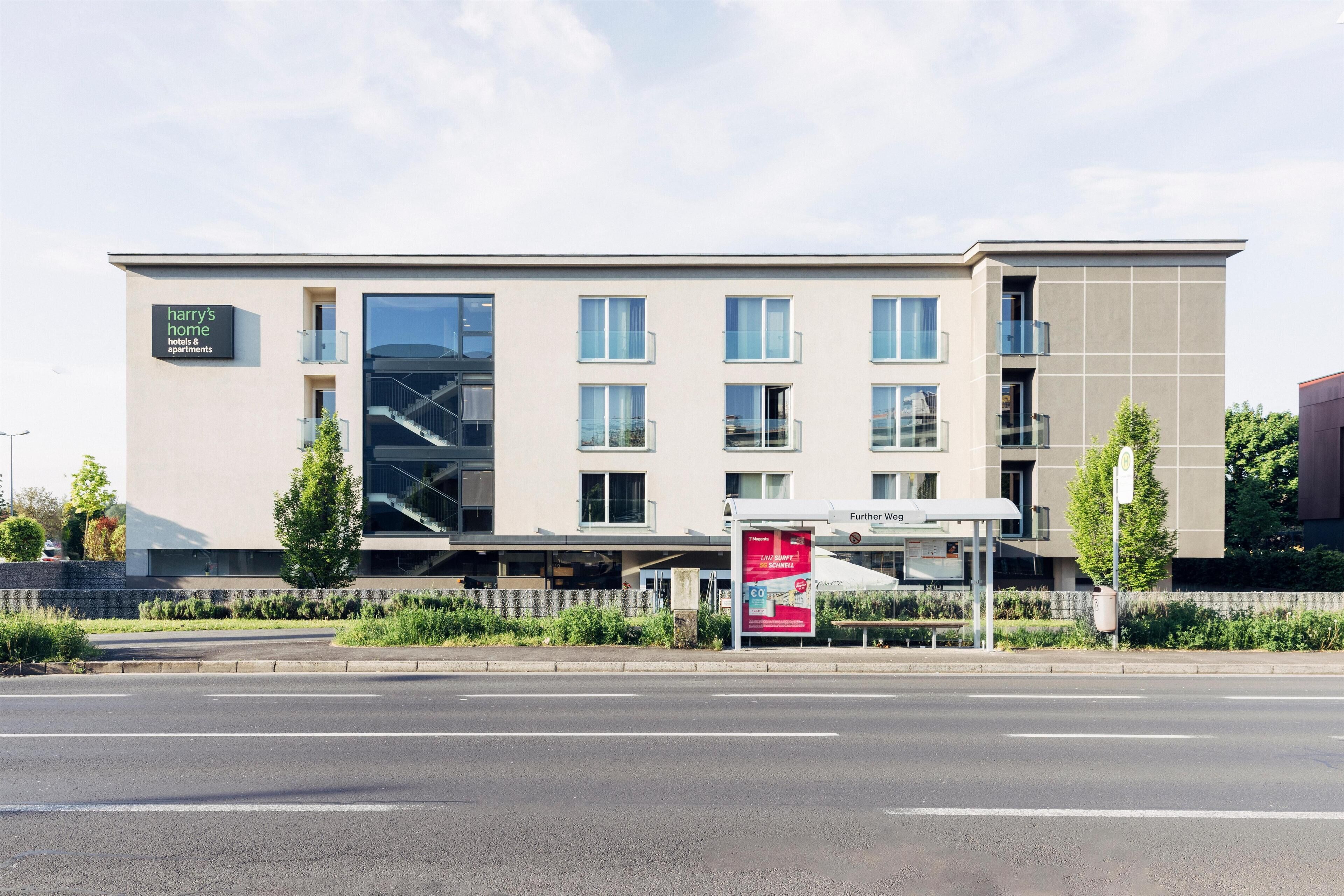 A modern hotel building with a sign reading "Harry's Home hotels & apartments."
