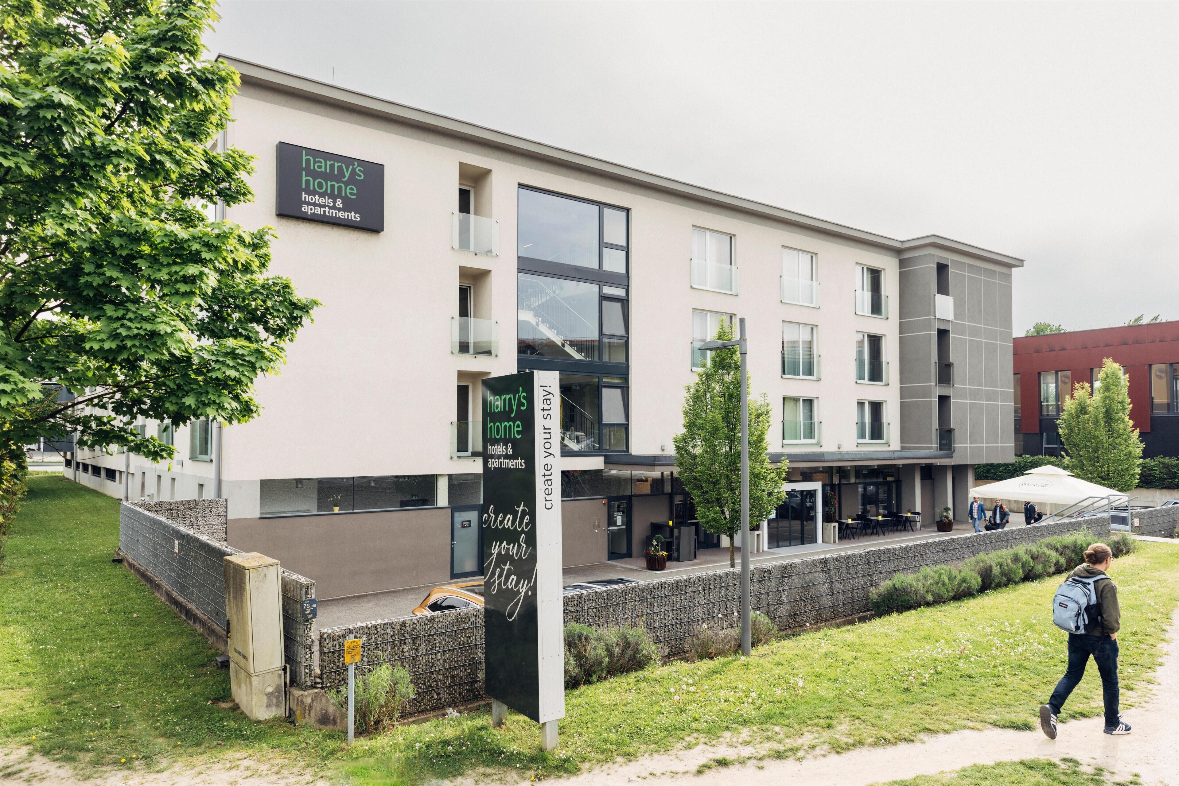 A modern building with a sign reading "Harry's Home hotels & apartments."