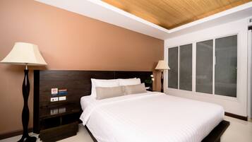 A modern bedroom with a large bed, wooden headboard, bedside lamps, and a window with frosted glass.