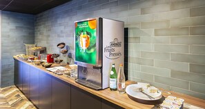 A breakfast bar with a beverage dispenser, a selection of fruits, and a bottle of wine. - Best Western Amarys Hotel & Spa (Rambouillet)