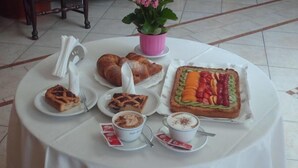 Una mesa con diversos pasteles, una tarta de frutas y tazas de café.